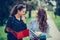 Two beautiful female friends, students checking paper notes before exam