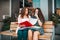 Two beautiful female friends, students checking paper notes and helping each other