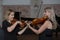 Two beautiful female violinists playing violin