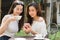 Two Beautiful freelance woman use social media on smartphone in