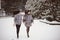 Two beautiful girlfriends hugging and smiling outdoors in winter. Two young female friends portrait closeup. Retouched, natural