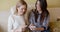 Two beautiful girls on couch listen to music