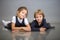 Two beautiful girls of the little sister pose lying on a gray background