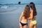 Two beautiful girls make a photo on the selfie-stick on the beach view from the back