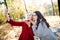 Two beautiful girls making selfie and blow kiss in autumn park