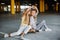 Two beautiful girls skateboarding, having fun and playing in the parking lot