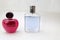 Two beautiful glass transparent shiny fashionable glamorous vials of cologne, perfume pink and blue with little caps and place for