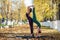 Two beautiful gymnasts do pair tricks on a portable platform in a beautiful autumn park. Two friends in the same body