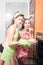 Two beautiful happy smiling & looking at camera young pinup women in aprons baking cake