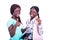 Two beautiful happy young women showing thumbs together while holding mobile phones