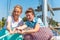 Two beautiful and joyful girls pull a rope on a yacht on the deck, laugh and joke.