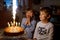 Two beautiful kids, little preschool boys celebrating birthday and blowing candles