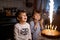 Two beautiful kids, little preschool boys celebrating birthday and blowing candles