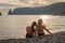 Two beautiful lgbt lesbian female friends relax and happy at the beach sitting on the sand wearing swimsuit. Travel and