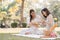 Two beautiful LGBT young women in casual clothes and summer hats Carefree woman having a picnic outside Positive model