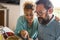 Two beautiful people middle aged eating couscous and vegetarian food looking at mobile phone - mature man and woman enjoying stay
