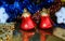 Two beautiful red bells on a brilliant background closeup with multicolored glittering garlands and snowflakes