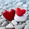 Two beautiful red hearts on background of gray stones