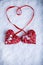 Two beautiful romantic vintage red hearts tied together with a ribbon on a white snow background. Love, St. Valentines Day concep