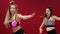 Two beautiful sports girls perform an active fat-burning workout jumping like a kangaroo in special fitness shoes