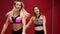 Two beautiful sports girls perform an active fat-burning workout jumping like a kangaroo in special fitness shoes