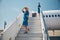 Two beautiful stewardesses standing on airplane stairs