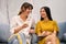 Two beautiful stylish girls joyfully talking on sofa in showroom