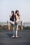 Two beautiful women doing yoga asana on the roof outdoors