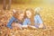 Two beautiful women lying on leaves and reading books in autumn park. Education, friendship lifestyle concept