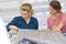 Two beautiful women selecting tissue at fabric shop