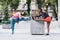 Two beautiful women stretching in city square after running and sport activity