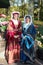 Two beautiful yound girls in traditional dress smiling welcome in spring time in Keukenhof flower garden. Many colorful