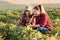 Two beautiful and young farmer girls examining crop of soy bean