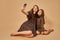 Two beautiful young girls sisters take selfies in nice animal pattern dresses with straw hats posing in studio