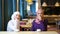 Two beautiful young Muslim women laughing and joking while sitting at a table in a cafe