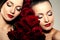 Two beautiful young women with amazing make-up in roses. Cosmetic care, makeup. Sensuality twins. Stylish attractive woman in flo