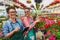 Two beautiful young women entrepreneurs in flower greenhouse using tablet for their business