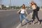 Two beautiful young women are hitchhiking on the road and try to find someone to take them to their hotel