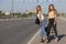 Two beautiful young women are hitchhiking on the road and try to find someone to take them to their hotel