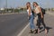 Two beautiful young women are hitchhiking on the road and try to find someone to take them to their hotel