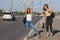 Two beautiful young women are hitchhiking on the road and try to find someone to take them to their hotel