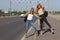 Two beautiful young women are hitchhiking on the road and try to find someone to take them to their hotel