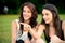 Two beautiful young women in a park pointing