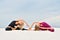 Two beautiful young women performing yoga pose Parivritta Janu Sirshasana