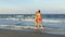 Two beautiful young women playing at the beach and dancing