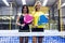 Two beautiful young women posing on paddle tennis court.