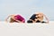 Two beautiful young women practice yoga on the sand