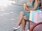 Two beautiful young women sitting on bench after shopping and eating icecream