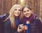 Two beautiful and young women walking in forest and drinking tea