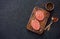 Two beefsteaks , peppers and old spoon, fork and cutting board o